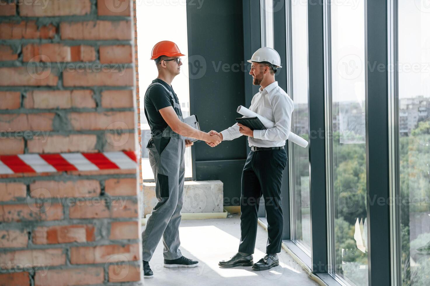 Manager with foreman, are working on the construction site together photo