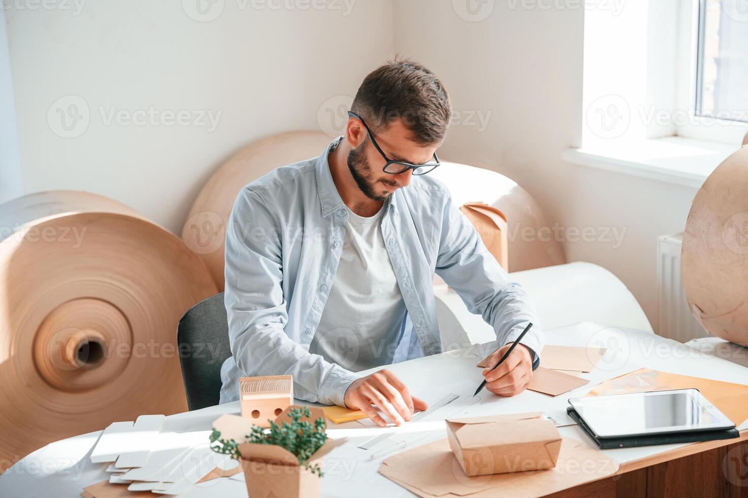 Drawing by the table.. Print house worker in white clothes is indoors photo