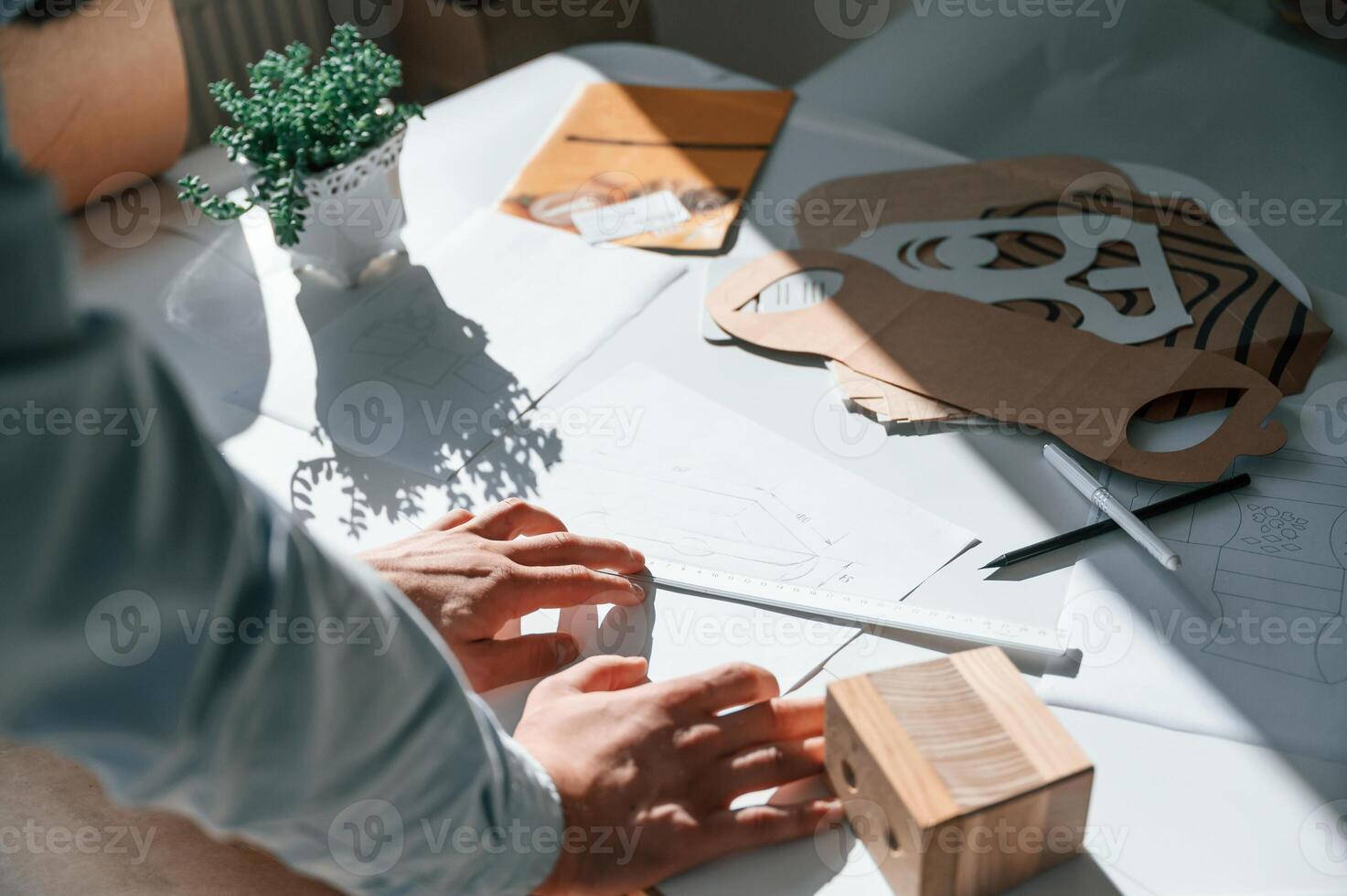 Doing, measurements and drawing, new design. Print house worker in white clothes is indoors photo