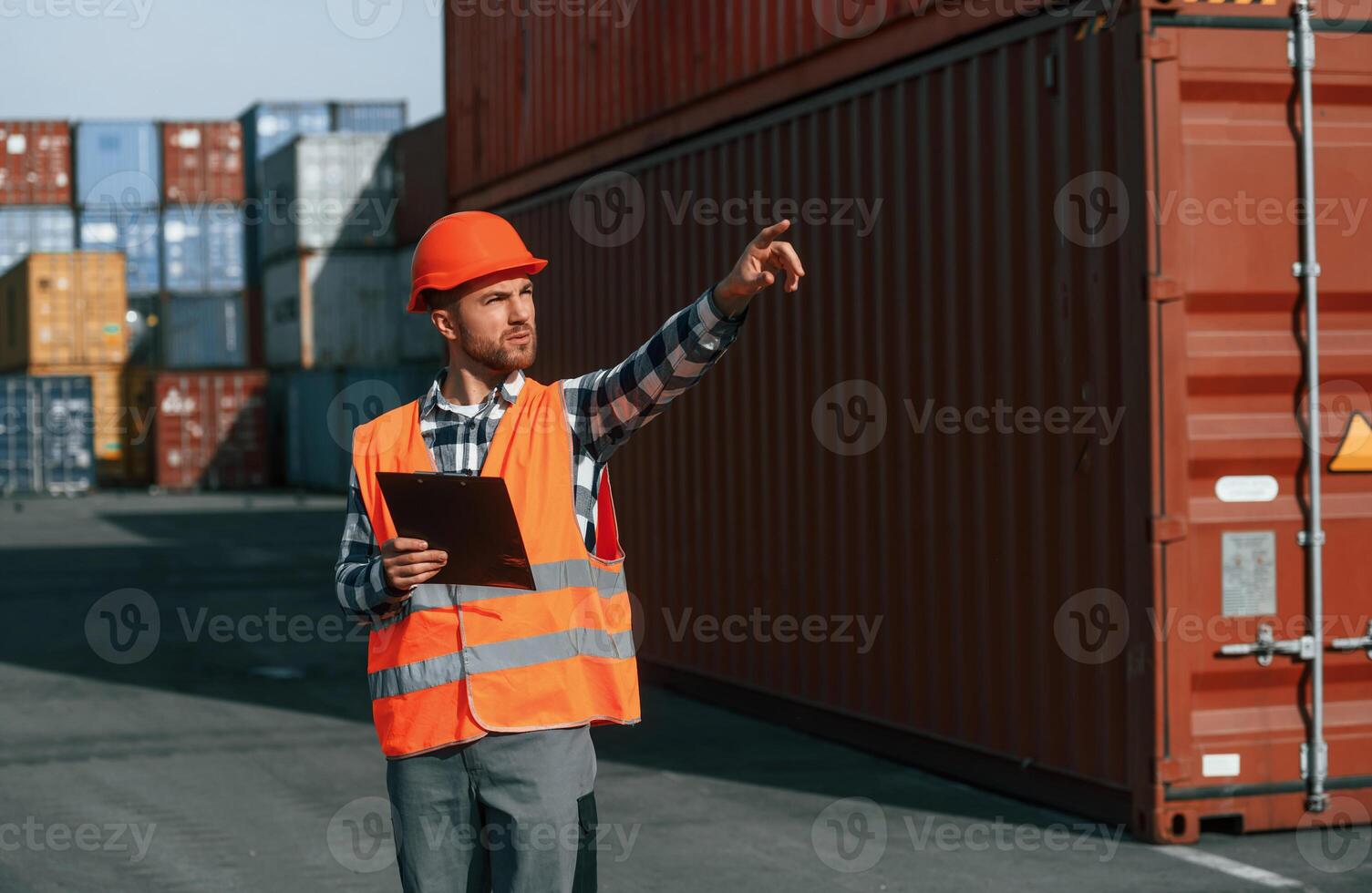 Giving, instructions, by the hand. Male worker is on the location with containers photo
