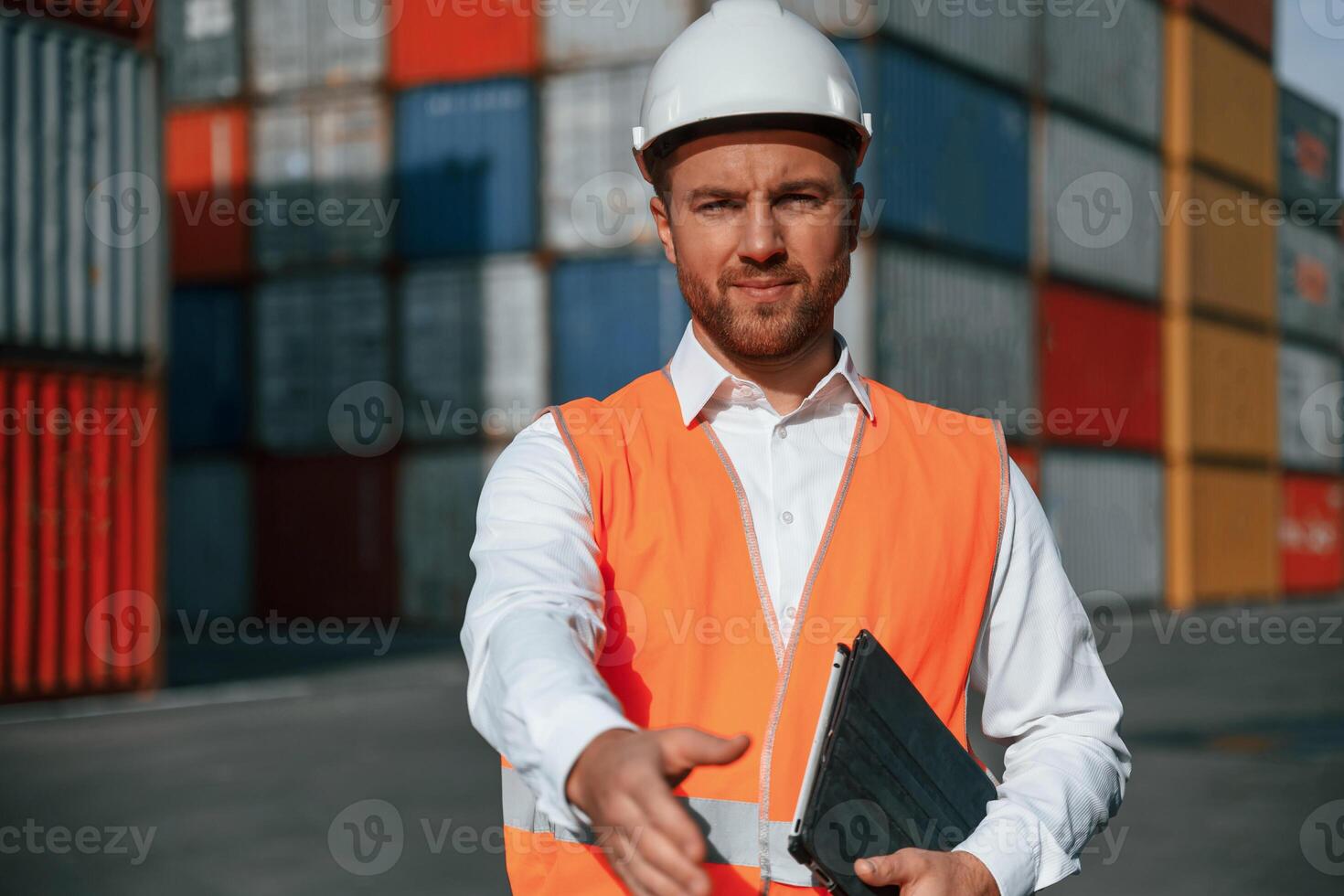 Giving hand to make, handshake, successful deal. Male worker is on the location with containers photo