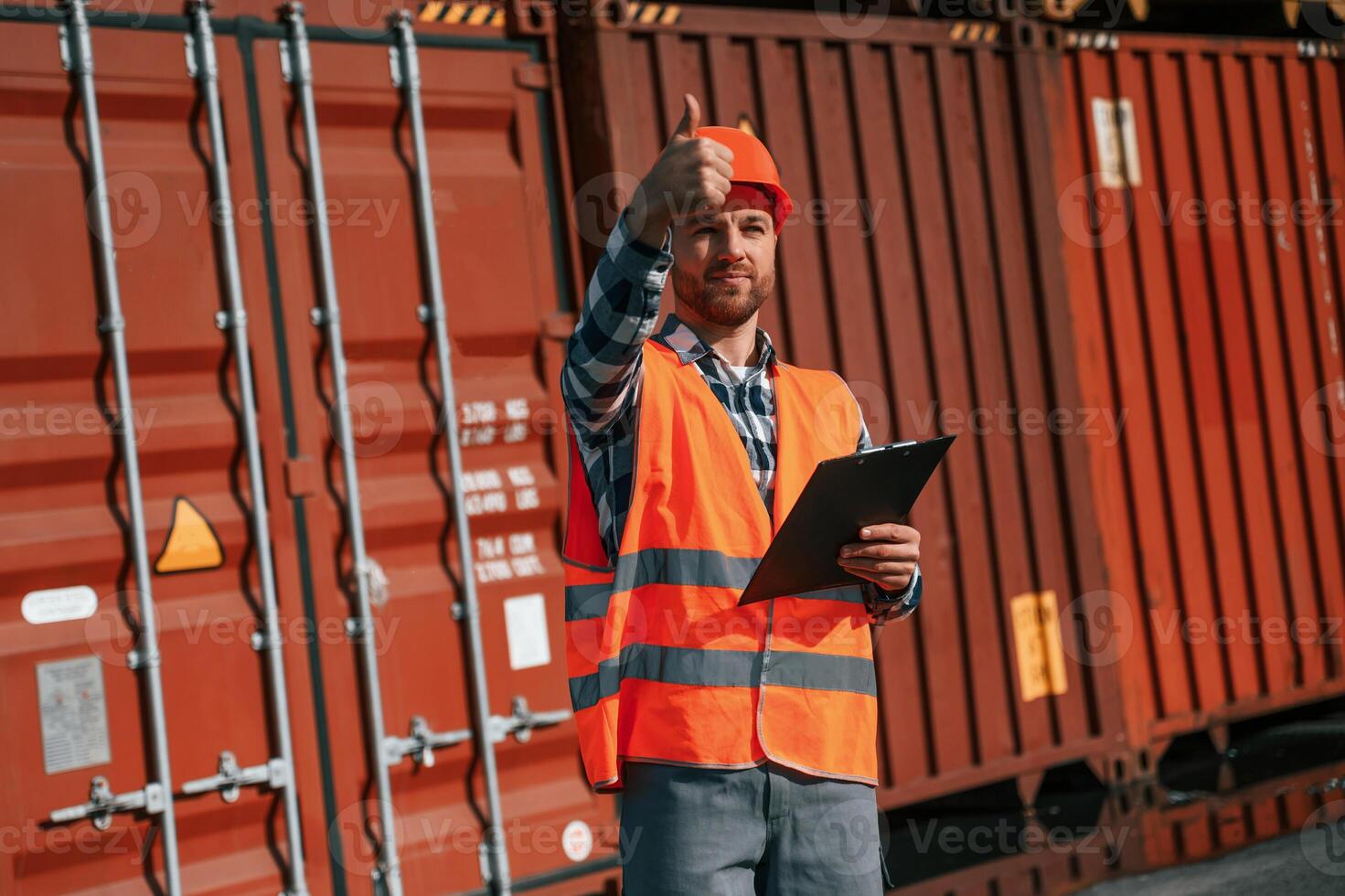 Digital, tablet in hands. Male worker is on the location with containers photo