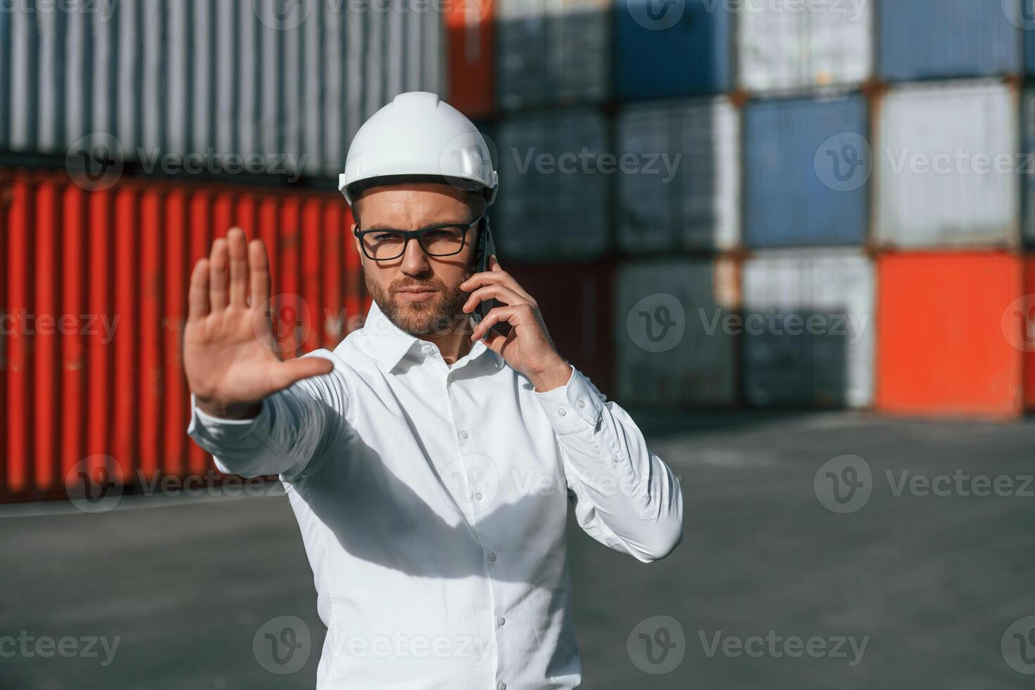 Restricted area. No trespassing. Male worker is on the location with containers photo