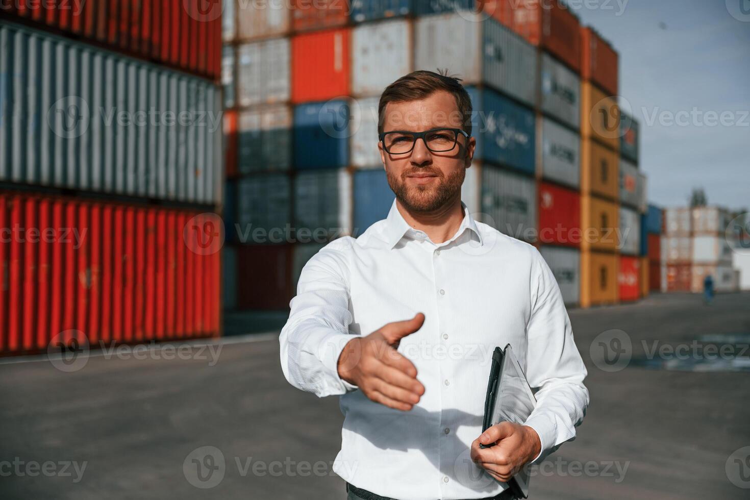Making, a deal, giving hand. Male worker is on the location with containers photo