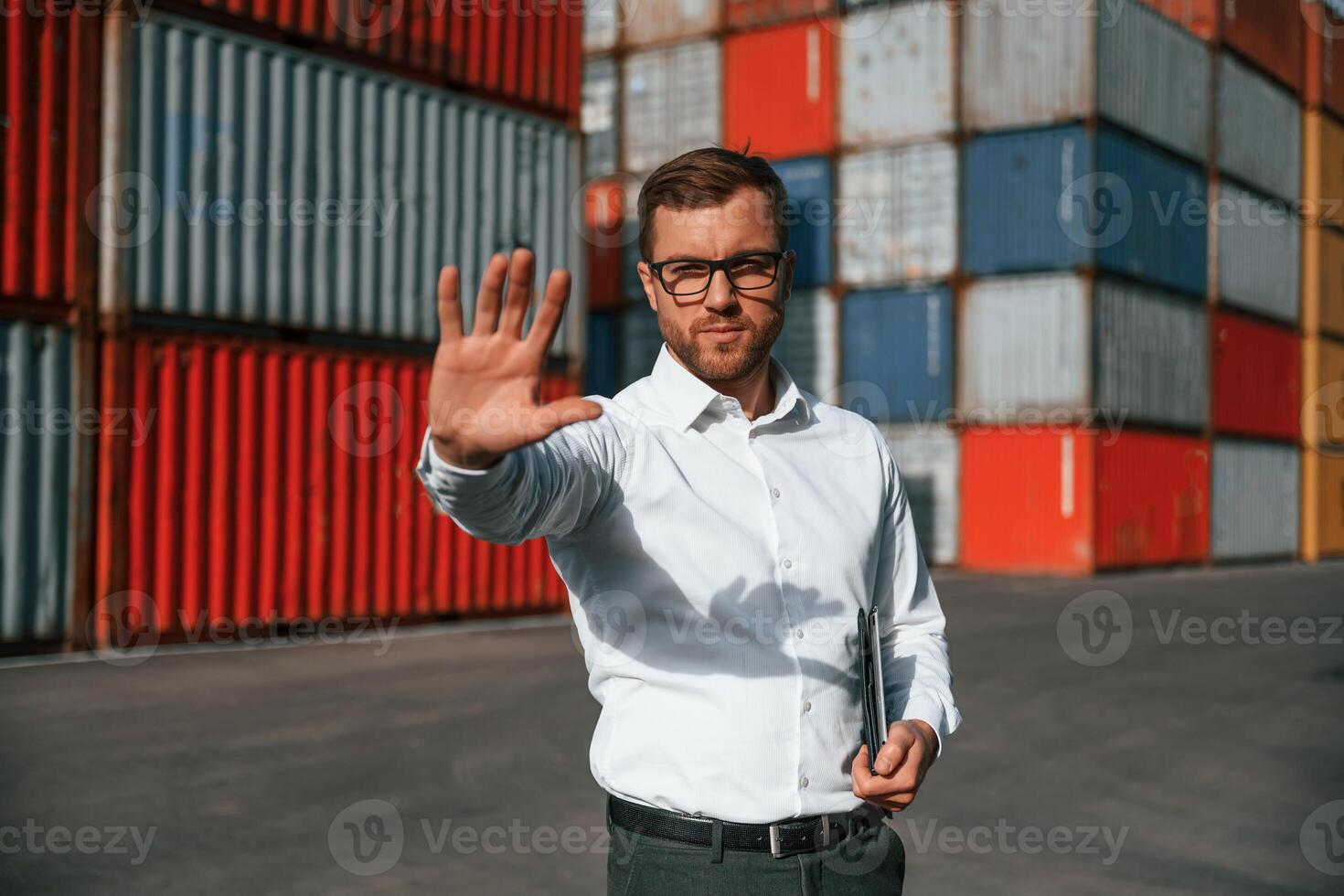 Restricted area. No trespassing. Male worker, is on the location with containers photo