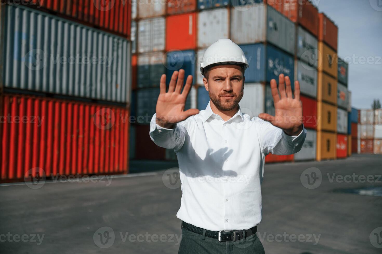 No trespassing. Area is closed. Male worker,, is on the location with containers photo
