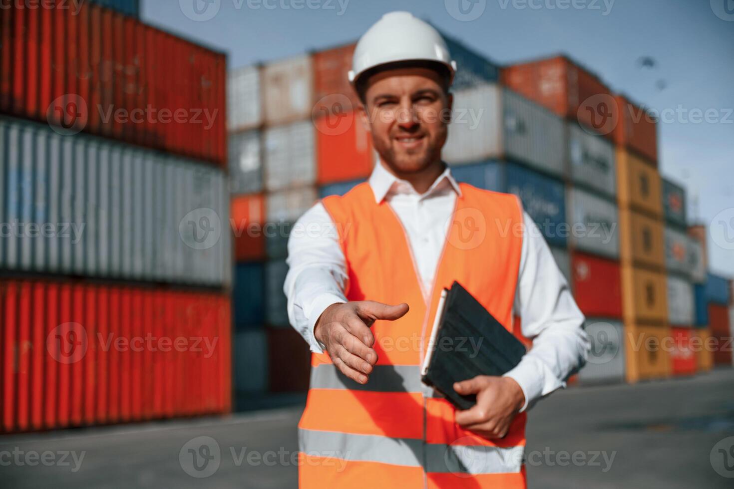 Giving hand to ,make handshake, successful deal. Male worker is on the location with containers photo