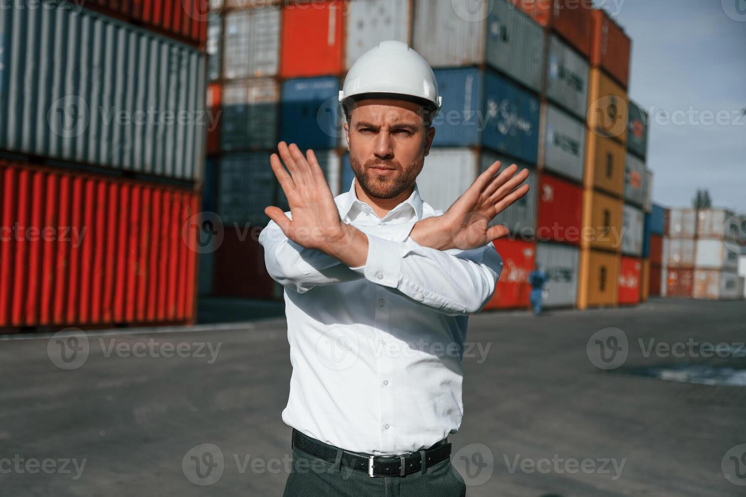 No trespassing. Area is closed. Male worker is on the, location with containers photo
