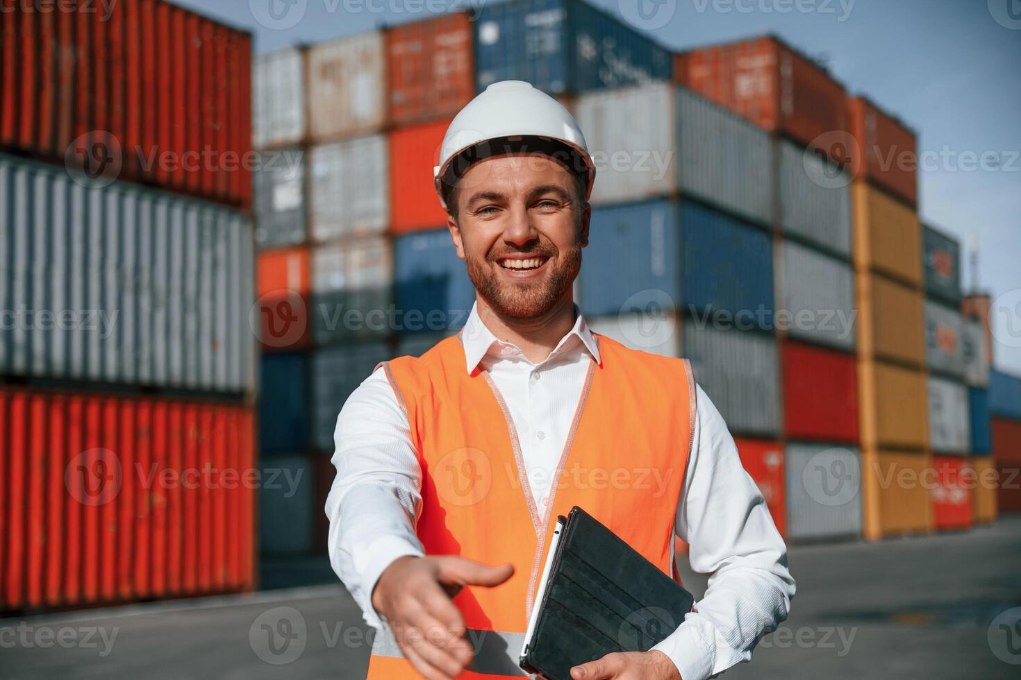 Giving hand to make ,handshake, successful deal. Male worker is on the location with containers photo