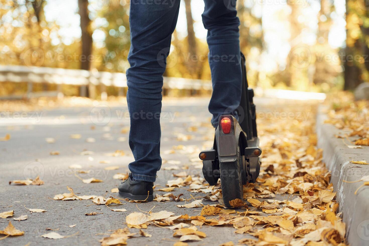 Close up view of eletric scooter that ,is riding by a man on the road photo