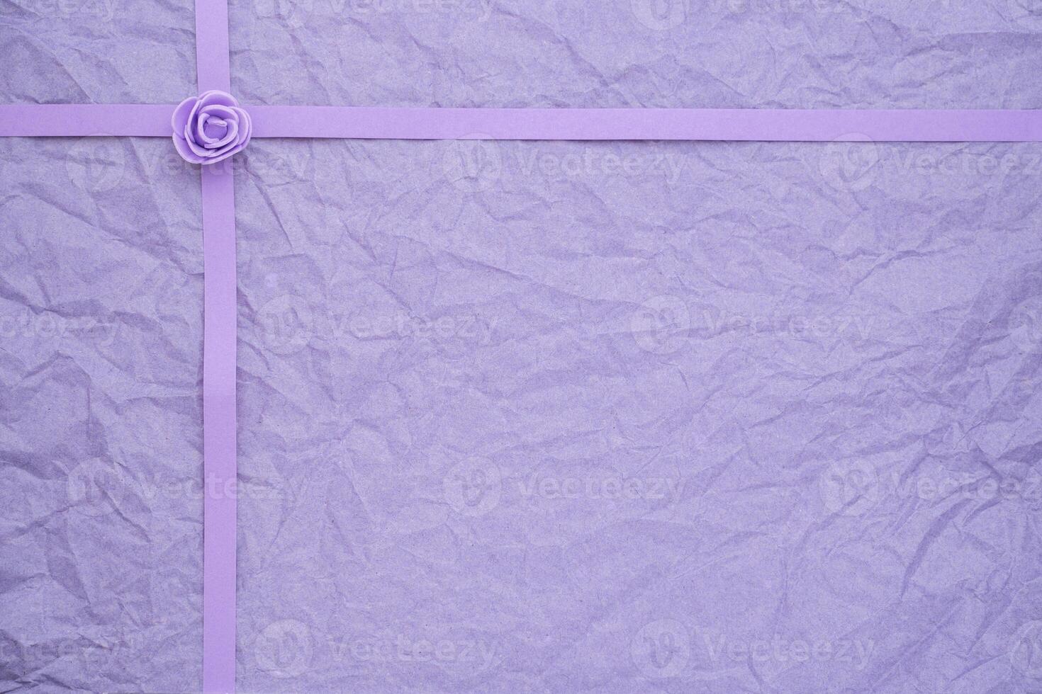 Crinkled violet paper with ribbon and rosebud texture photo