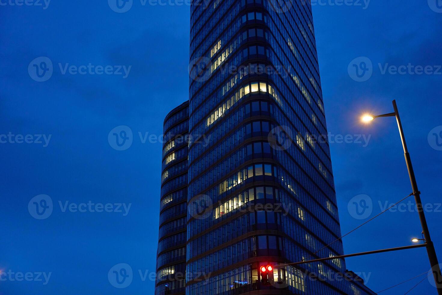 Modern high-rise office building with illuminated windows at night photo