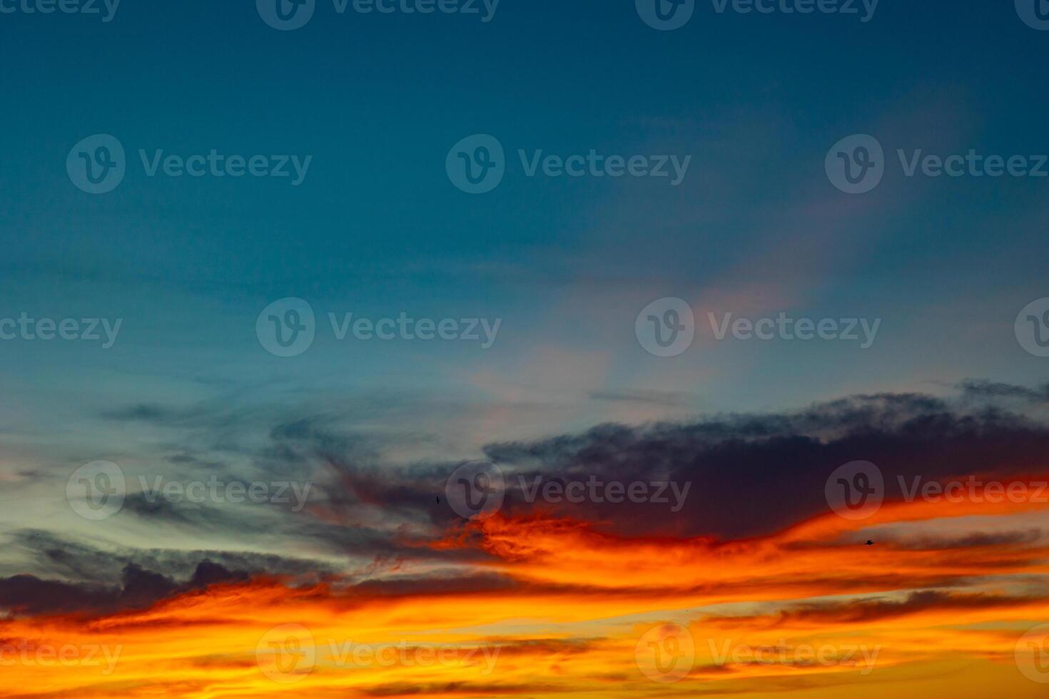 Dramatic orange clouds with sunrays at sunset. photo