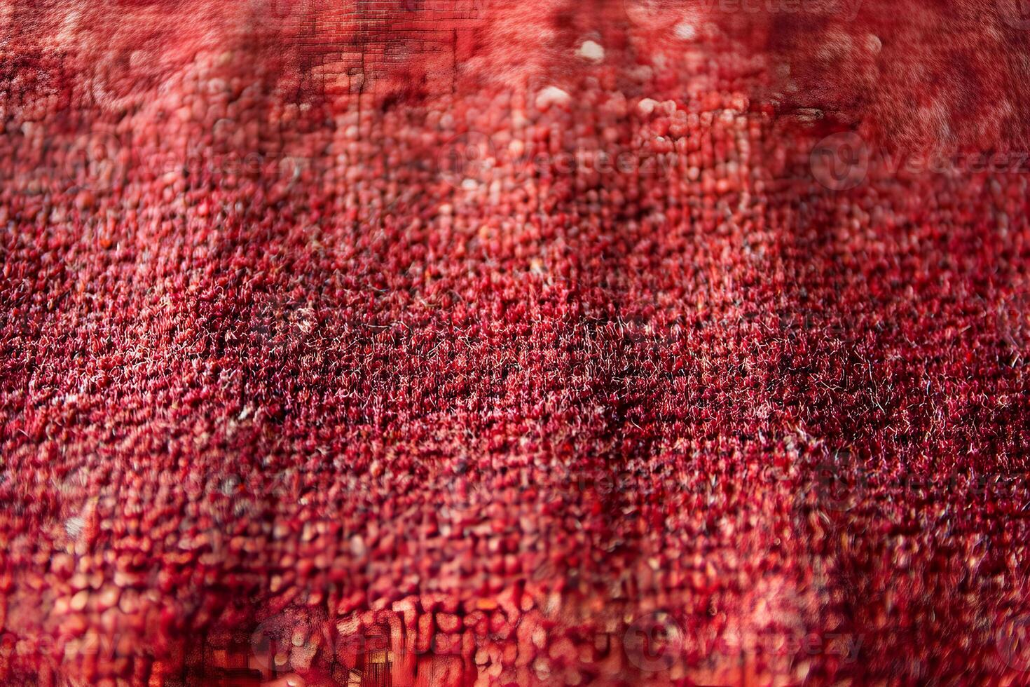 A close-up view of red knitted fabric, showcasing intricate textures and patterns. The macro shot highlights the details of the yarn and weave, creating a cozy and inviting atmosphere. photo