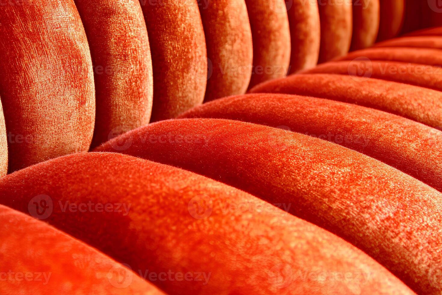 A close-up view of the rich and luxurious texture of a red velvet sofa, highlighting its softness and elegant appearance photo