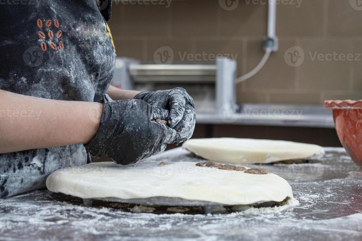 Girls at work in the production of dumplings. gloved hands make dumplings from meat. without faces and persons. High quality photo