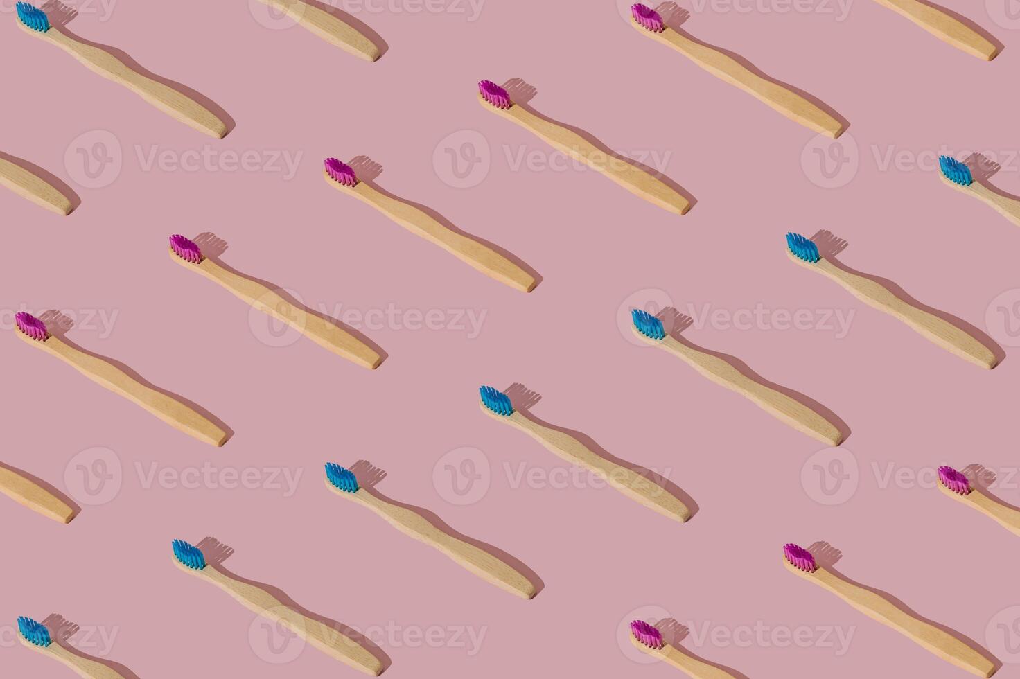 Organic bamboo toothbrush pattern composition on pastel pink background. Trendy dental concept. Creative eco friendly, biodegradable and natural wooden toothbrush pattern backdrop idea. photo