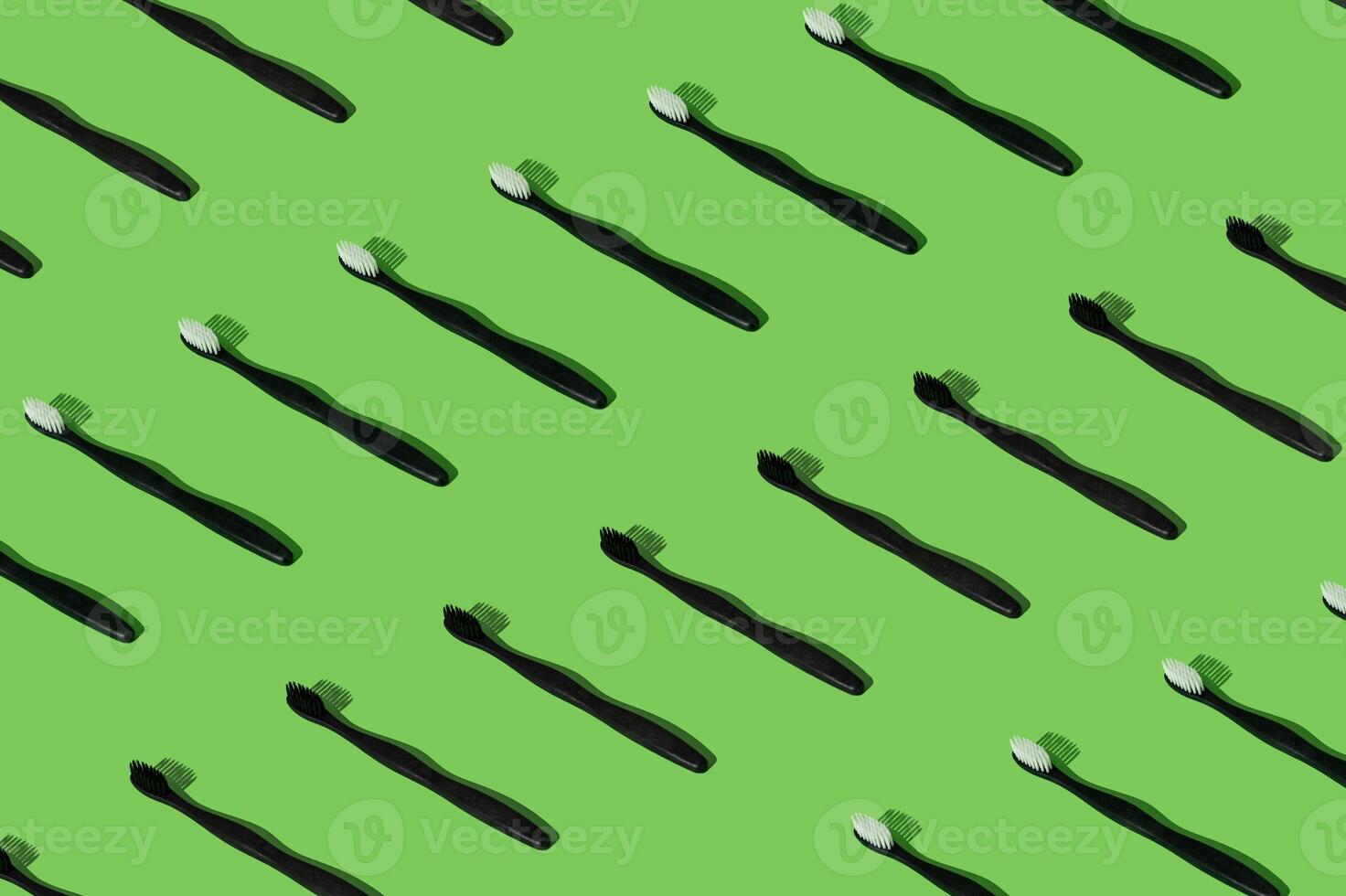 Organic plant based toothbrush pattern composition on green background. Minimal dental concept. Creative eco friendly, biodegradable and natural wooden toothbrush pattern backdrop idea. photo