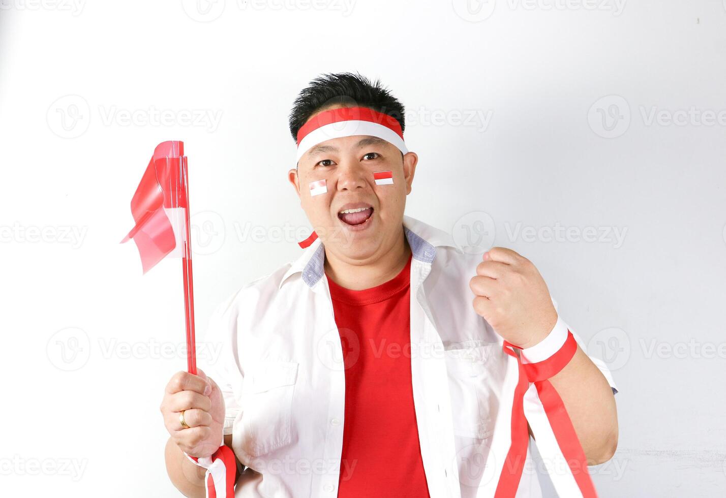 Happy Indonesian Man making Yes gesture and holding Indonesian Flag during Independence Day Party photo