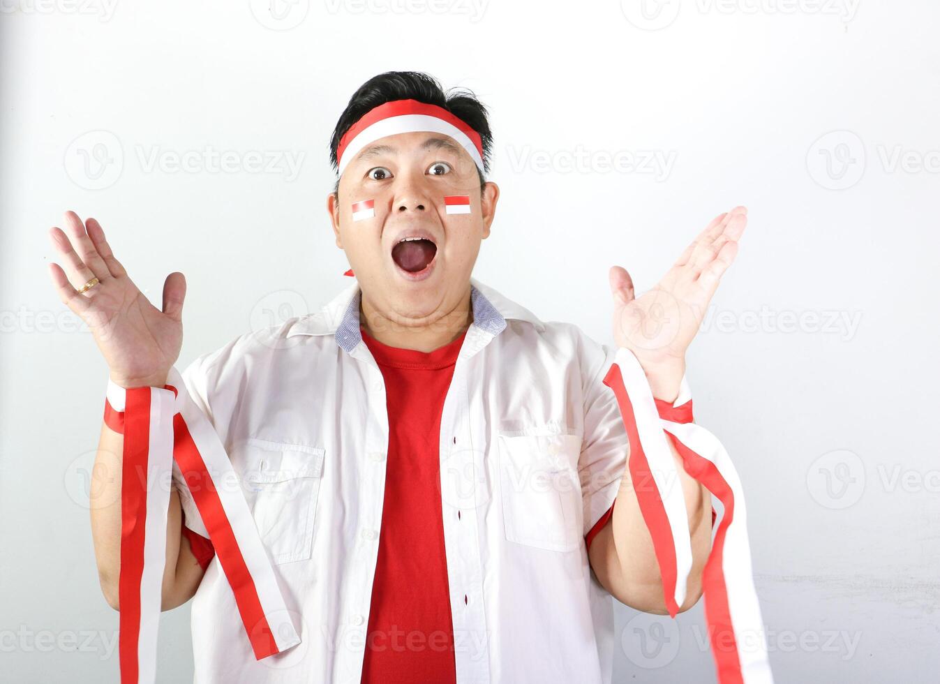 Excited Indonesian Man wearing red and white headband with both hands open and mouth open saying WOW photo