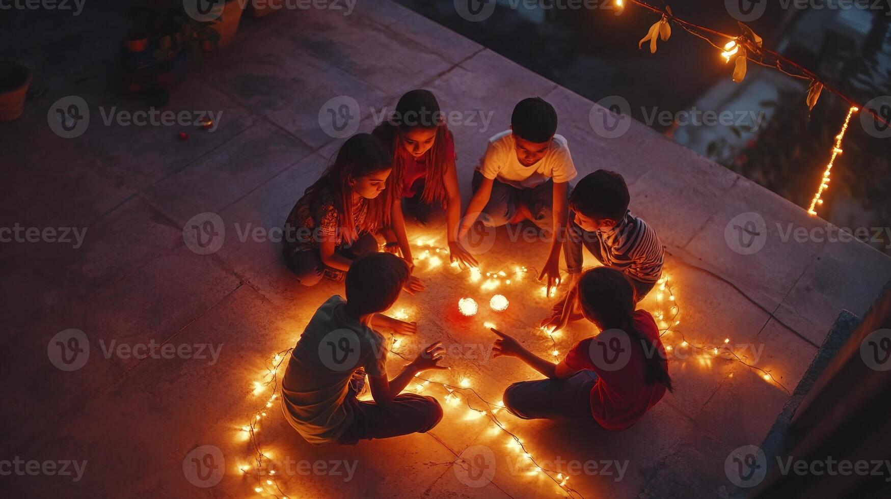 Four children sitting on the ground with candles photo