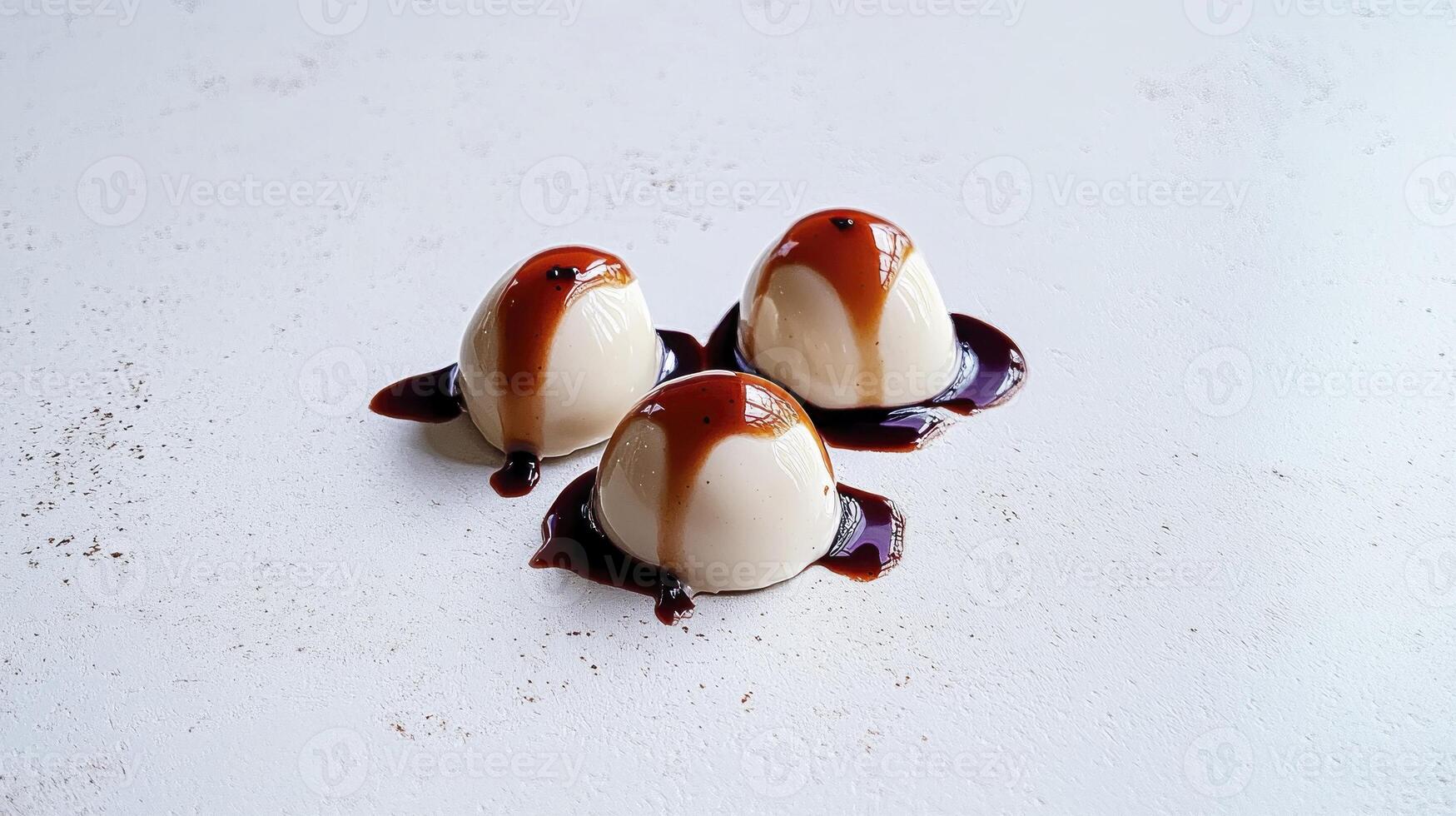 Three dessert balls with caramel sauce on top photo