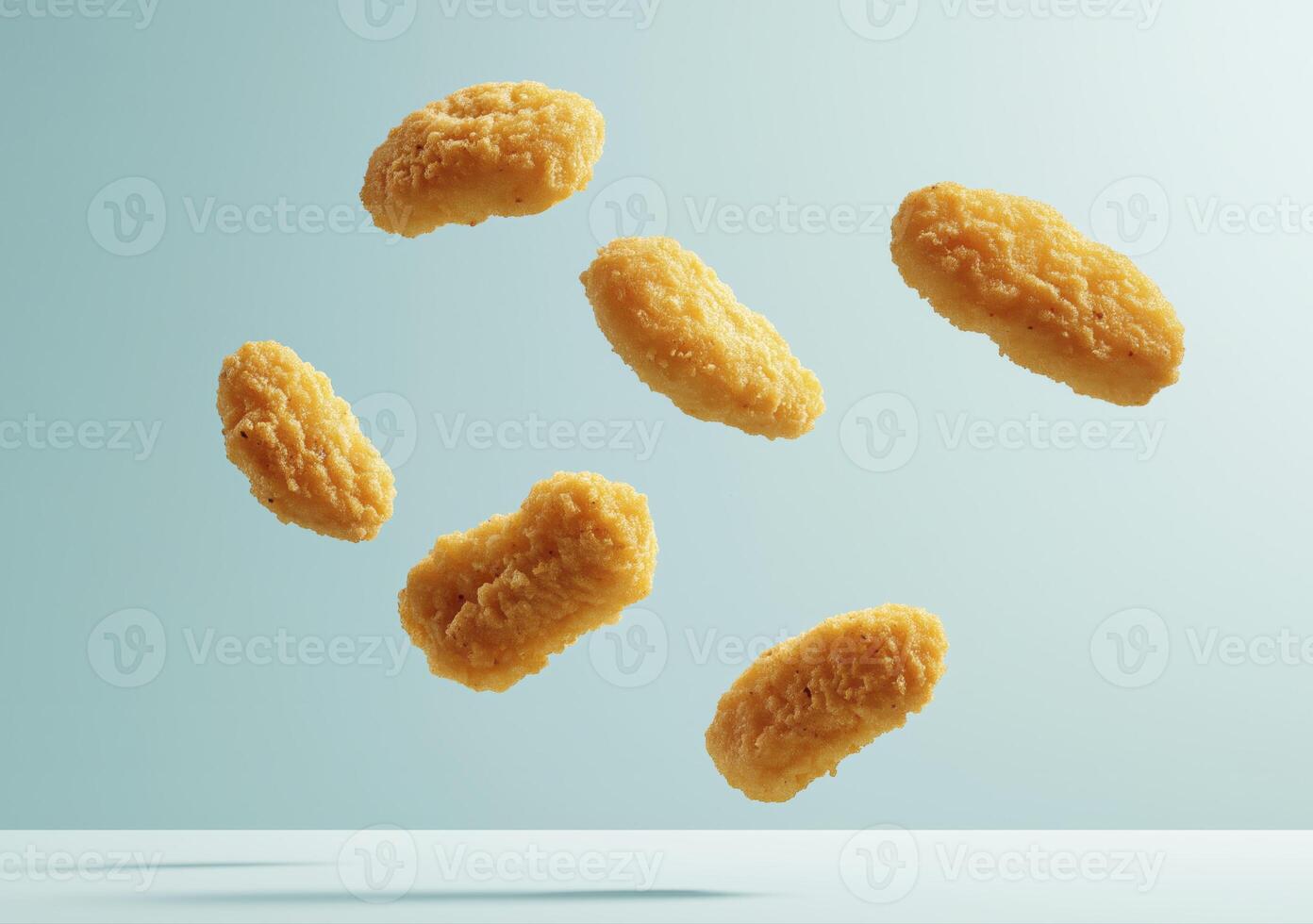 Crispy chicken nuggets falling in air on blue background photo