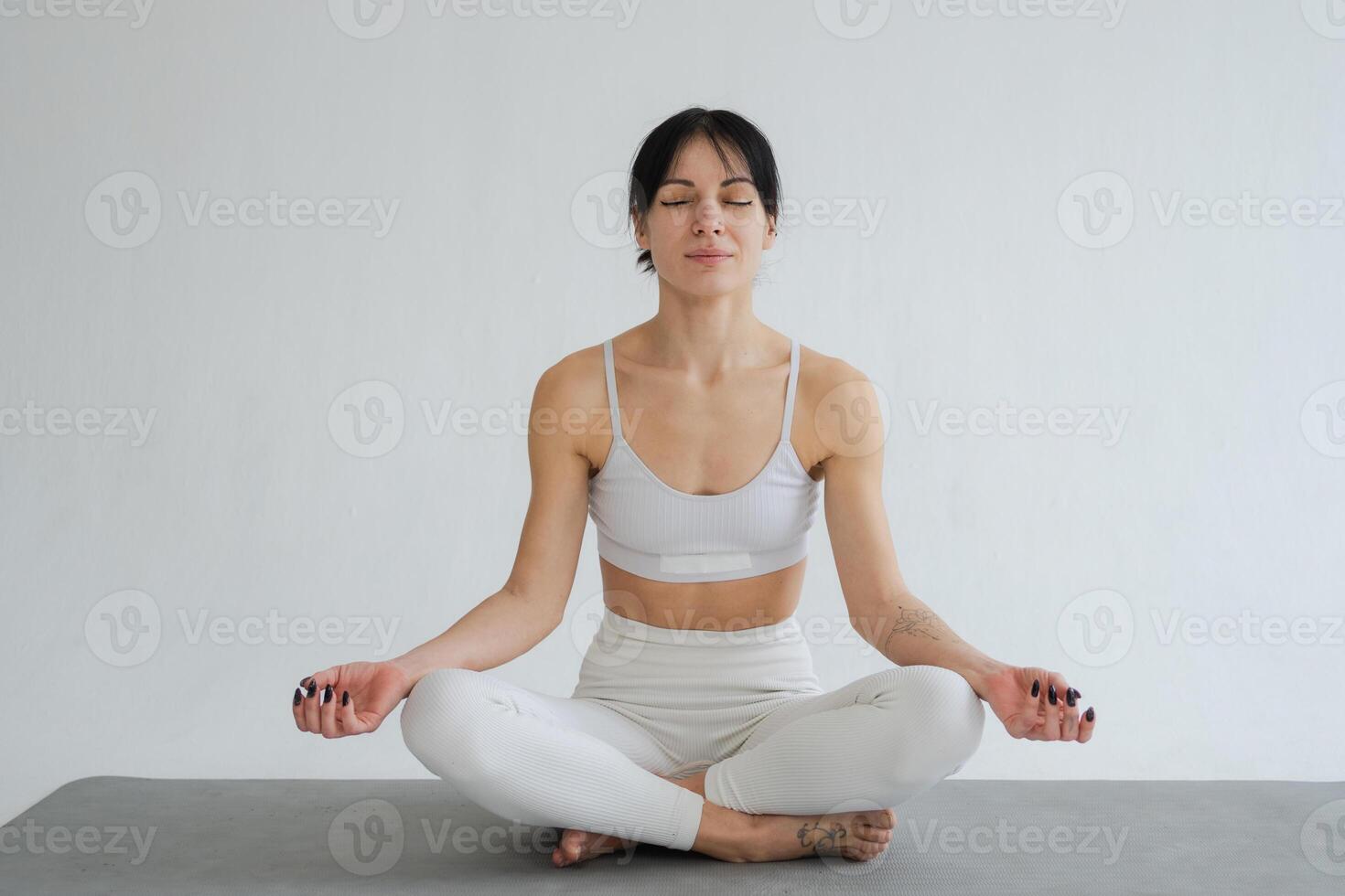 Yoga mindfulness meditation. Healthy woman practicing yoga isolated on white background. Woman sitting in lotus pose meditating relaxing. Girl doing breathing practice. Yoga on white background photo