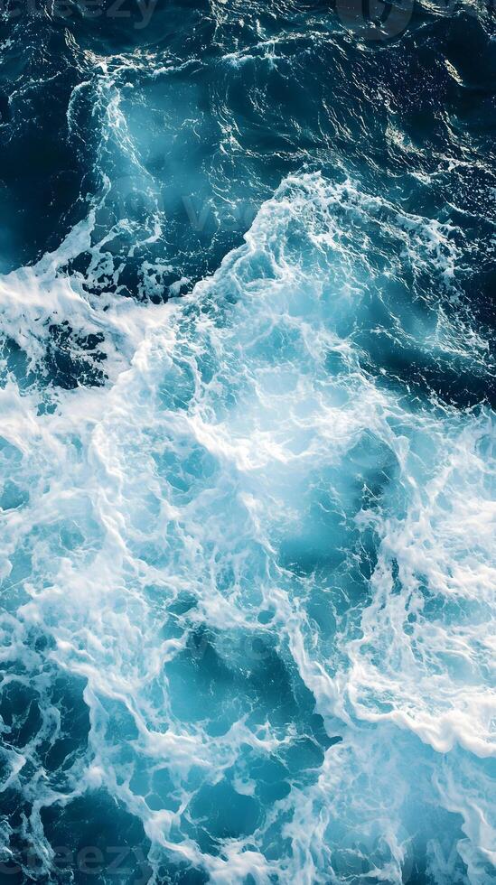The ocean is blue and has white waves photo