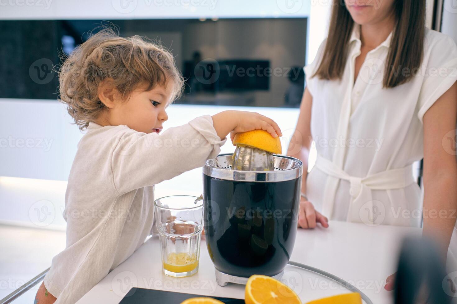 Mother and son making fresh juice at home photo
