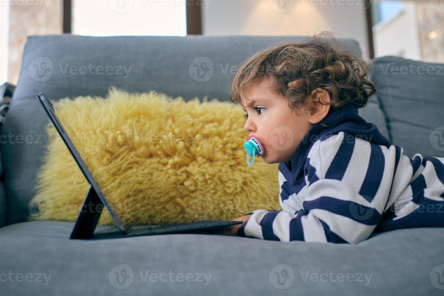 Little boy watching interesting cartoon at home photo