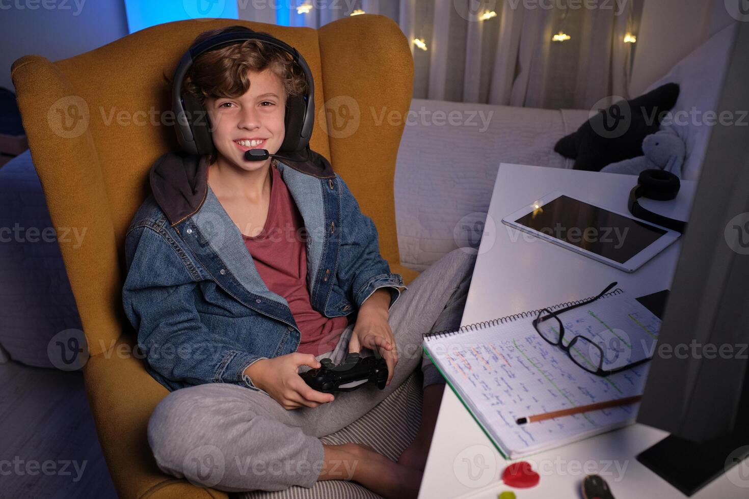 Child in headset enjoying game on computer in dark room photo