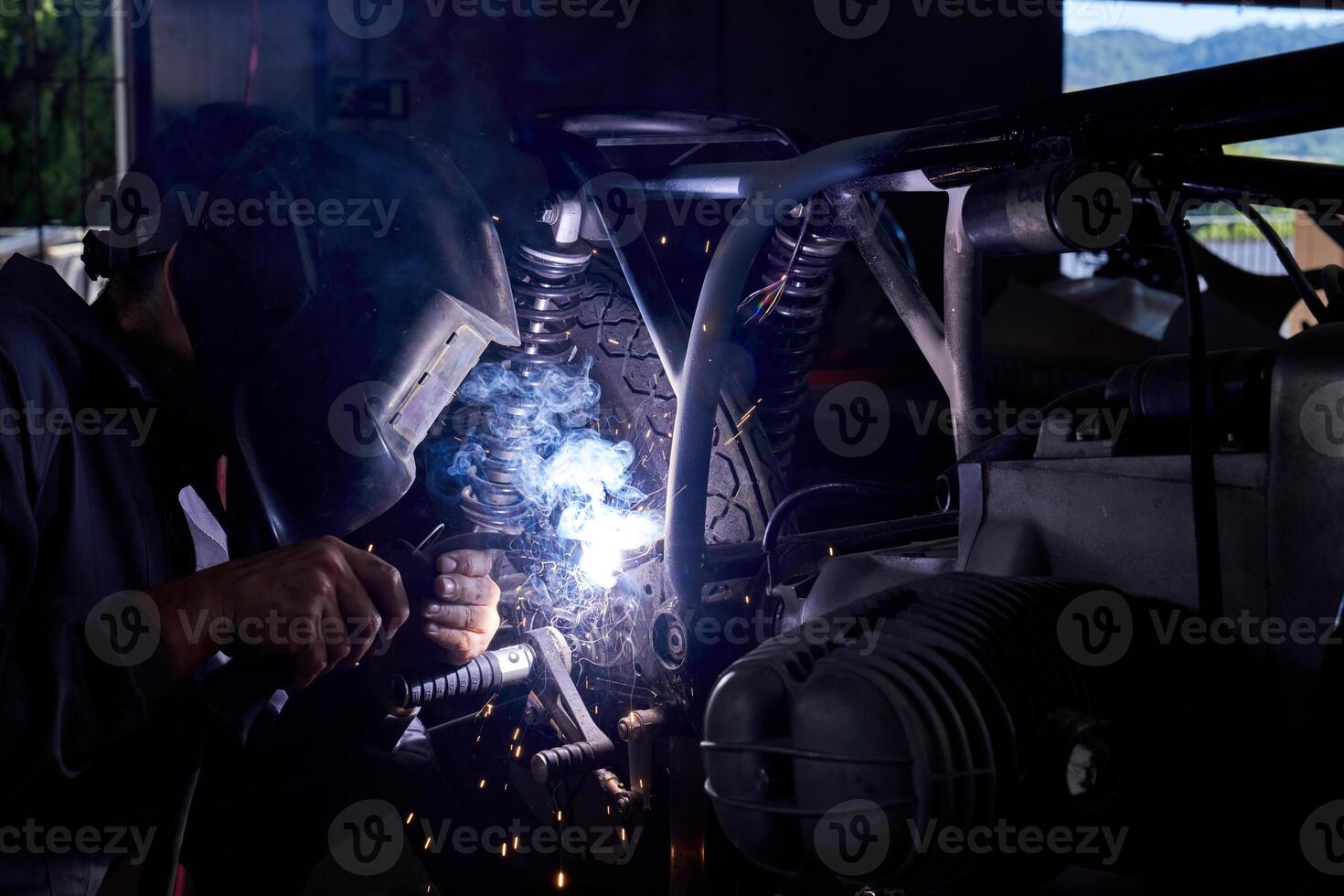 Male mechanic welding motorcycle parts photo