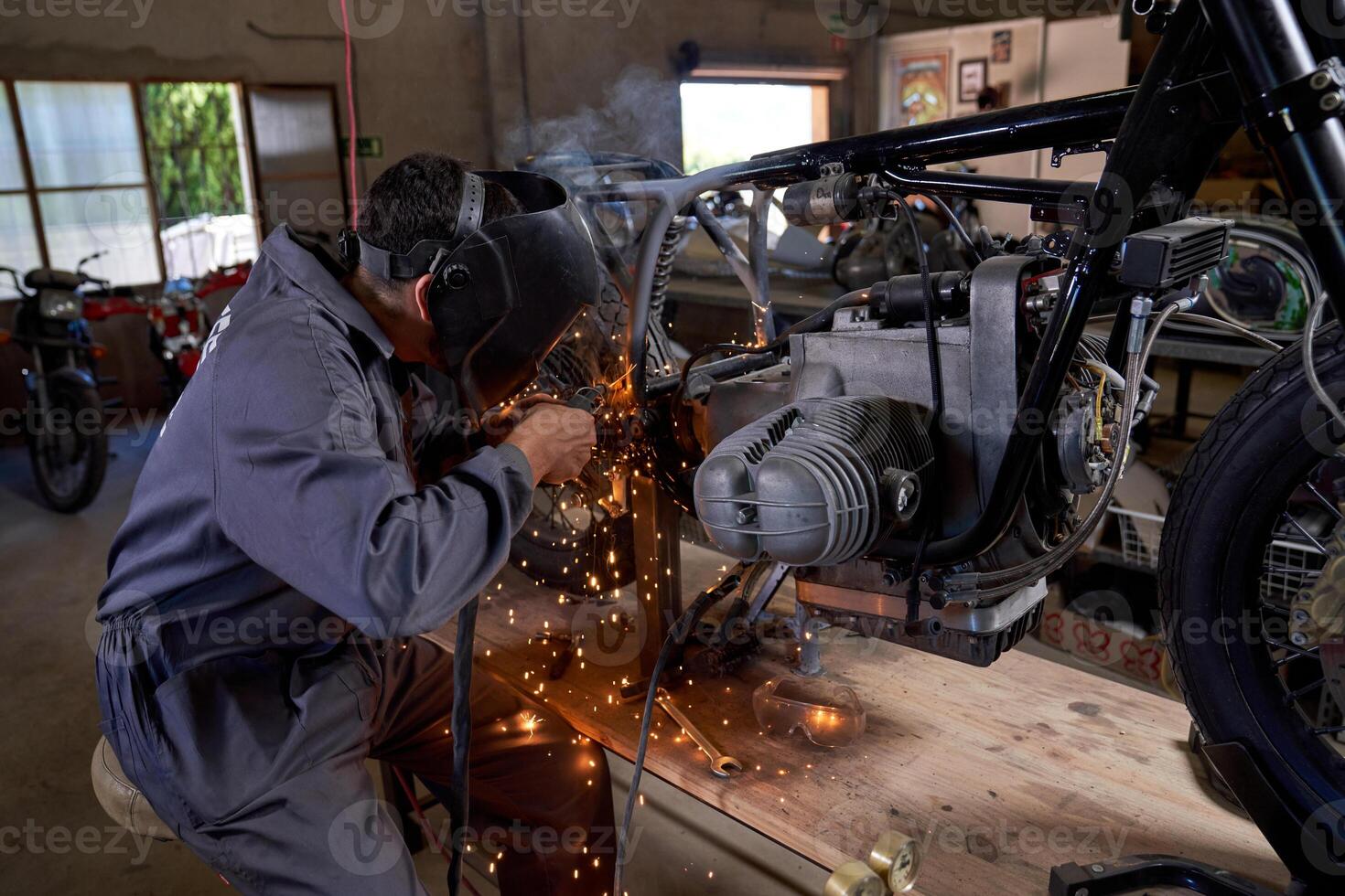 Anonymous technician working with welding machine while repairin photo