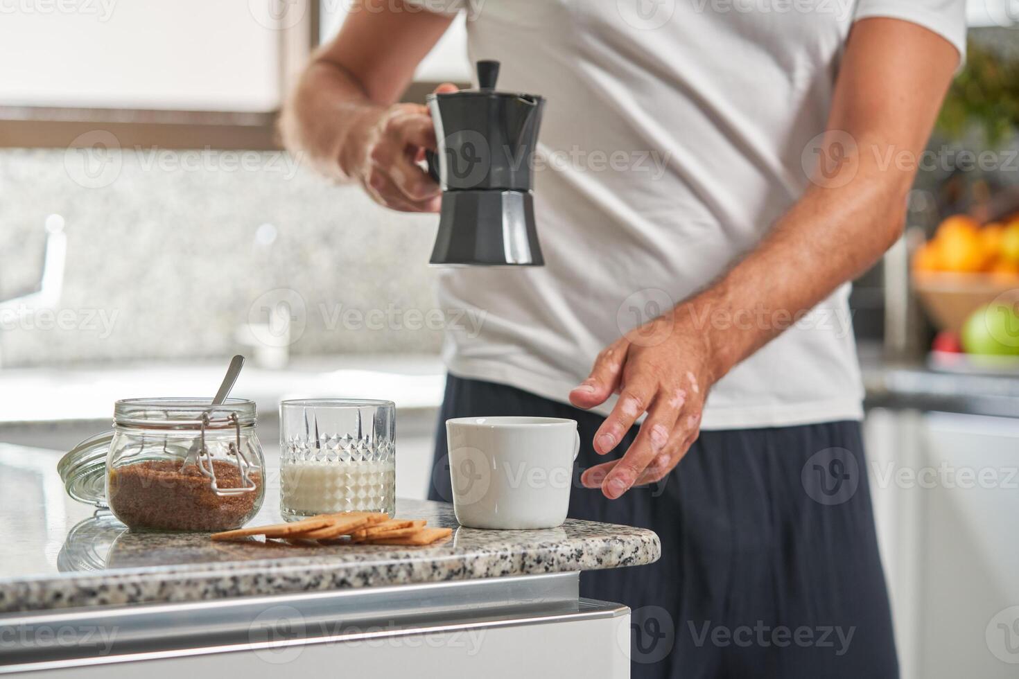 Unrecognizable man pouring hot coffee from moka pot photo