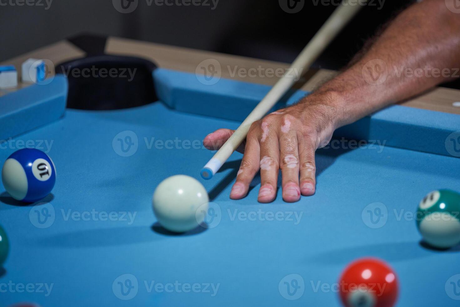 Crop man playing billiards at home photo