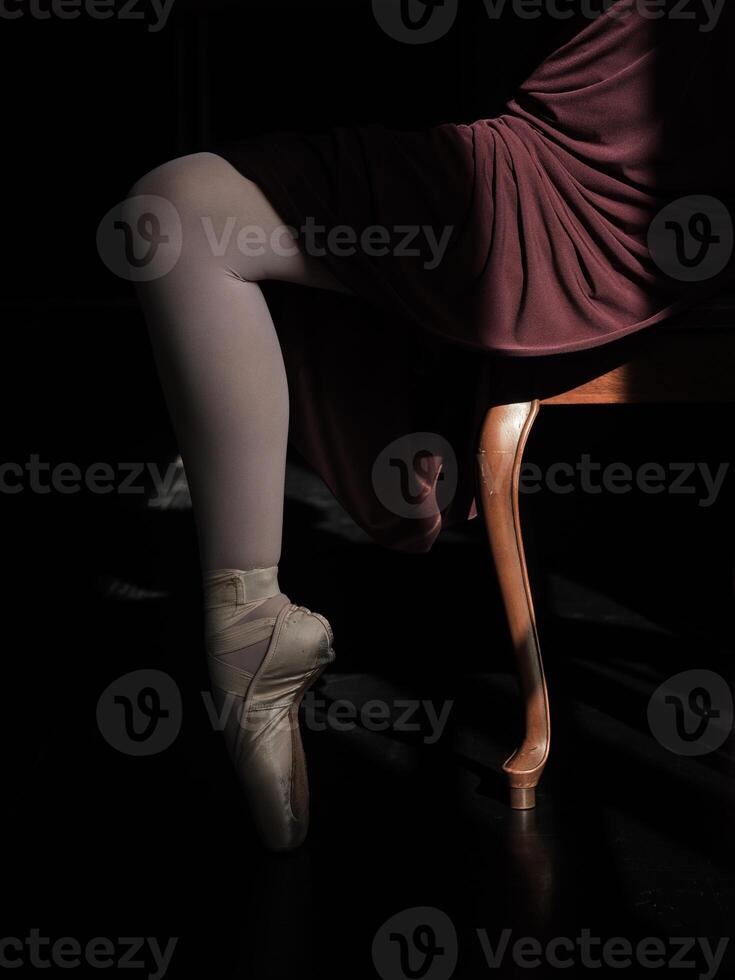 Leg of ballerina standing on tiptoe in pointe shoes photo