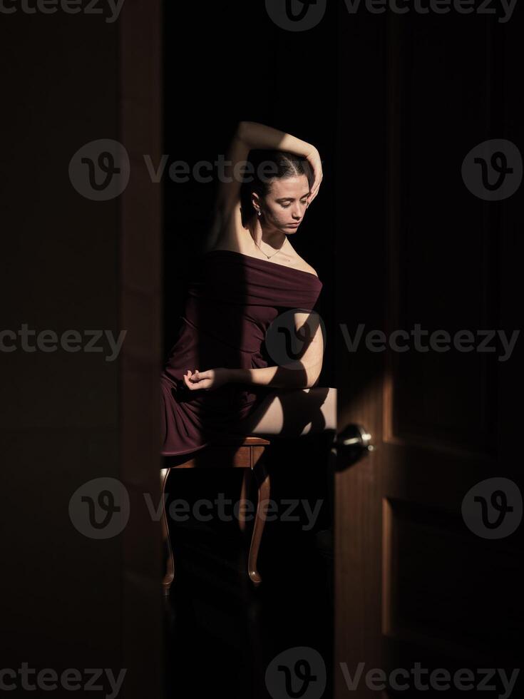 Sensual ballerina sitting on chair and touching head photo