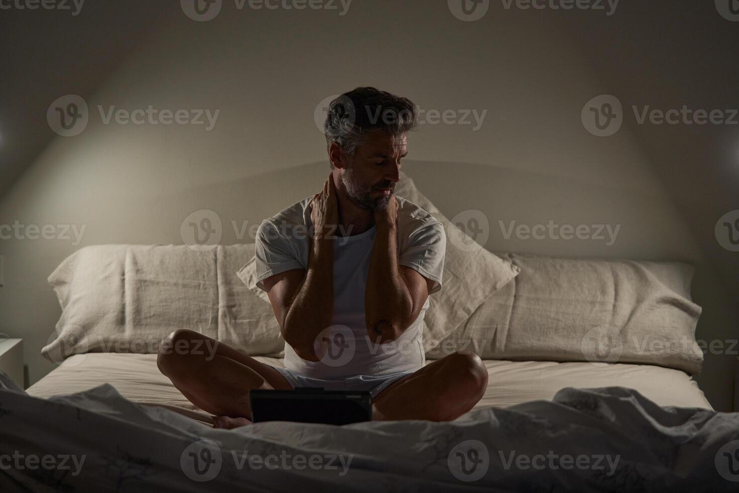 Exhausted mature ethnic man resting after working on tablet in b photo