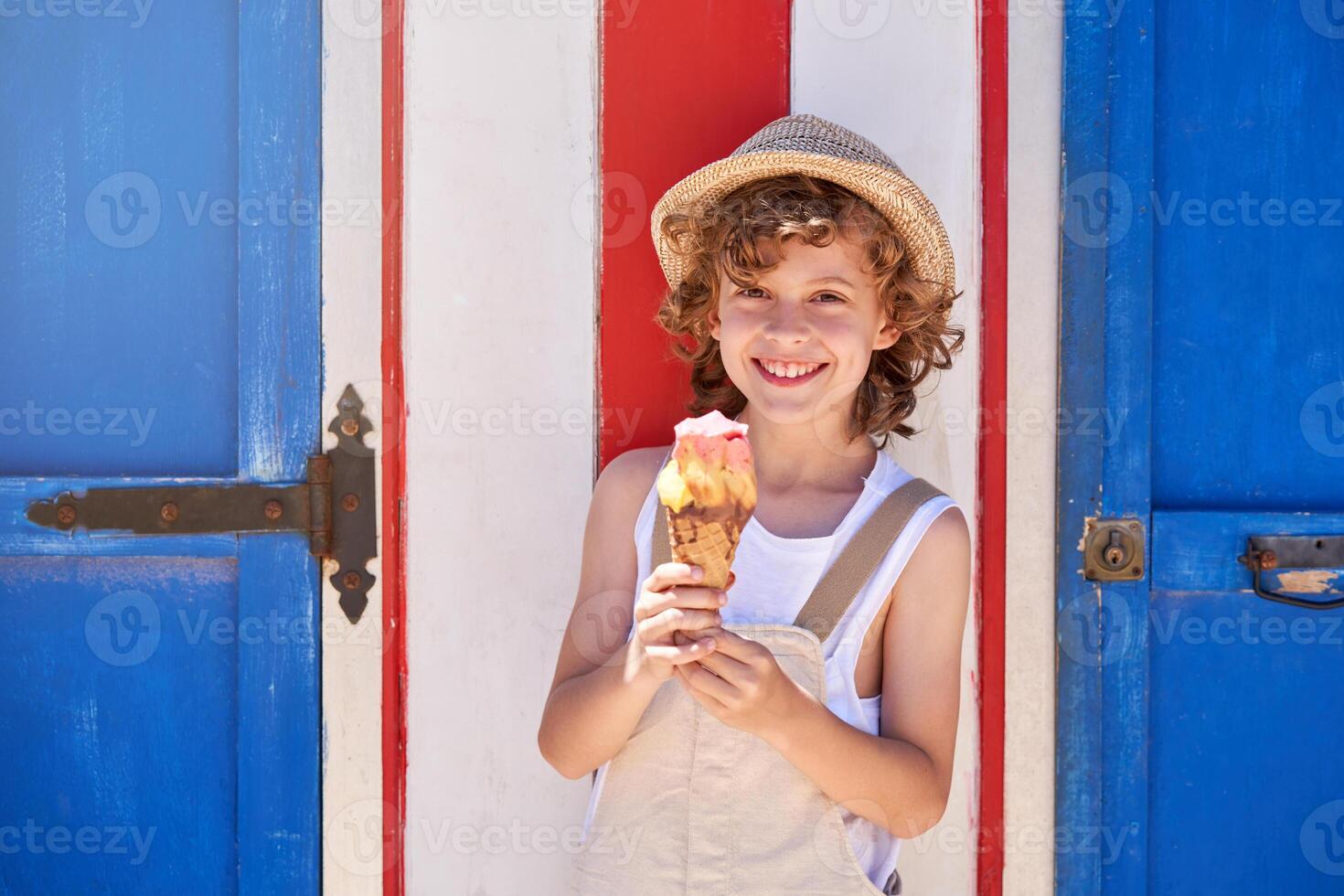 Cheerful boy with ice cream cone on street photo