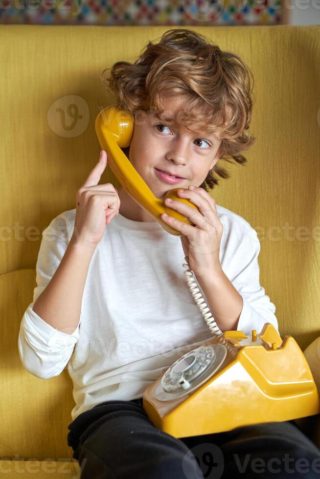Content child having conversation on retro phone photo