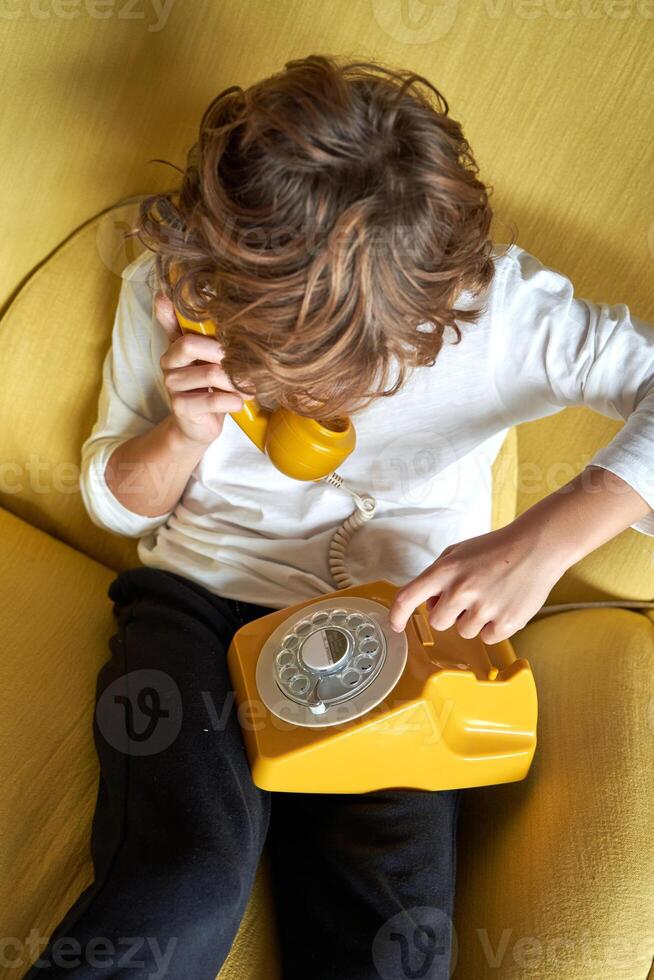 Boy having conversation on landline telephone photo