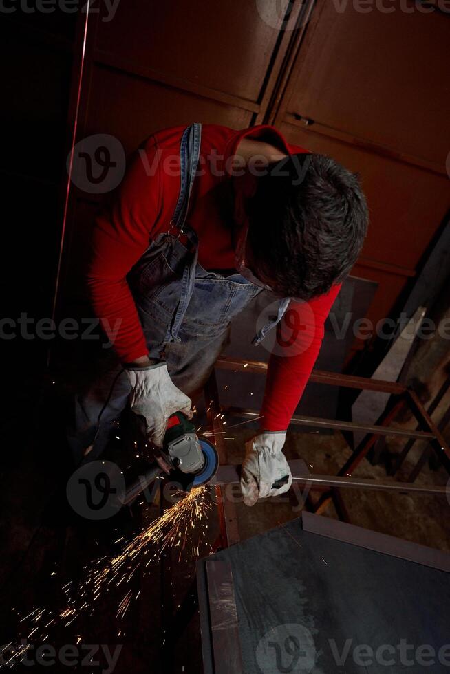 Master cutting metal plank by angle grinder photo