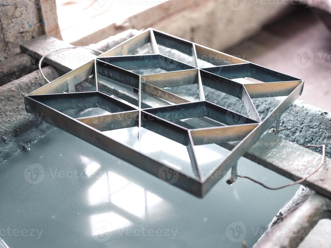 Metal mold above water in workshop photo