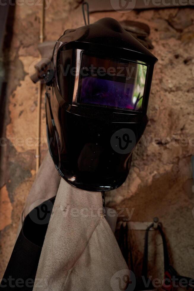 Mask of welder hanging on wall photo