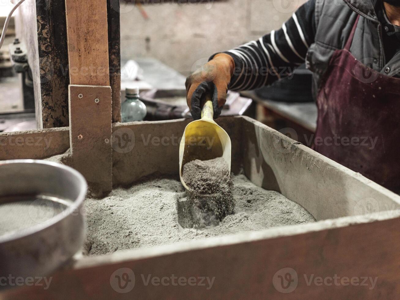 Unrecognizable worker scooping dry material photo