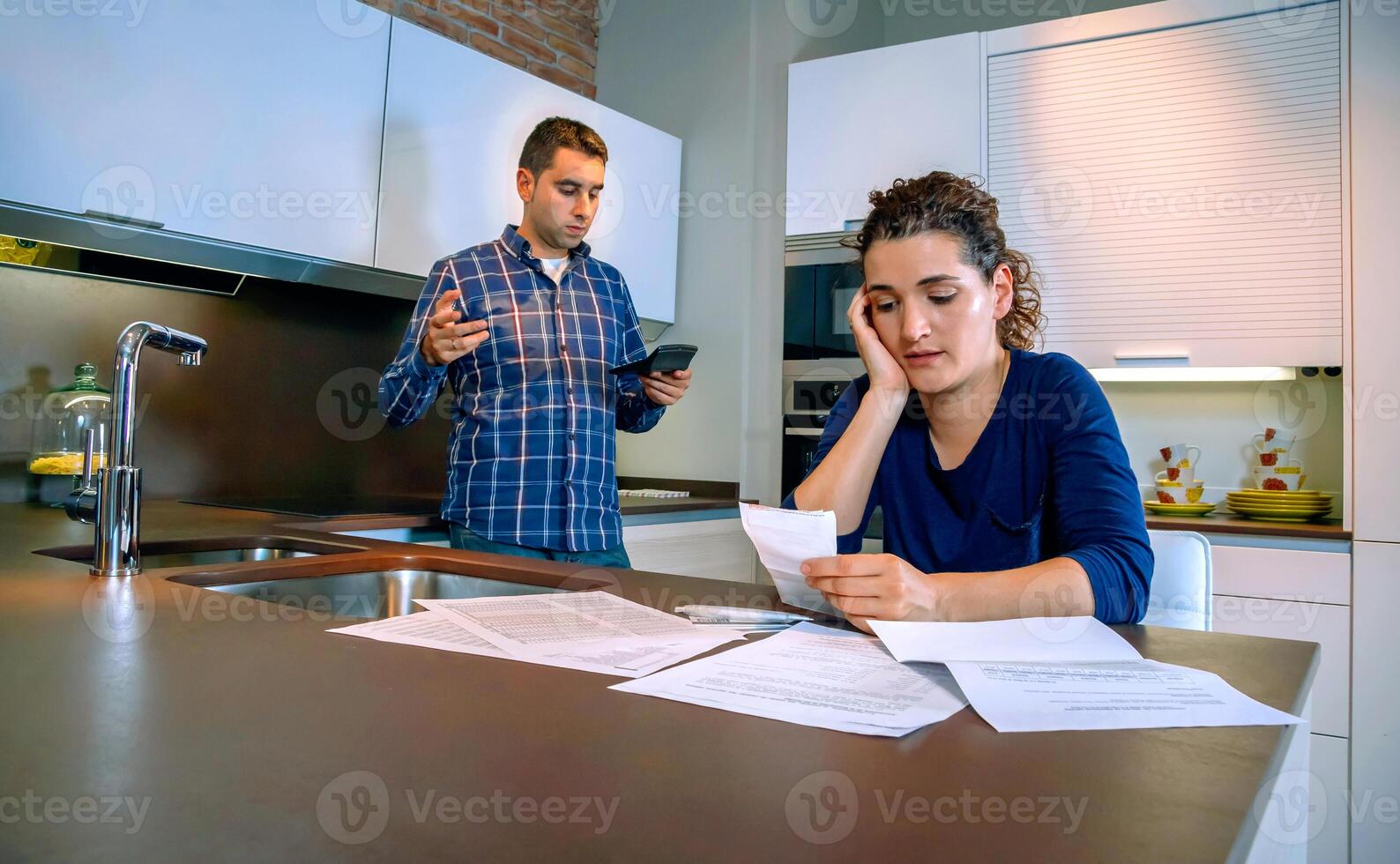 Desperate young couple with debts reviewing their bills photo