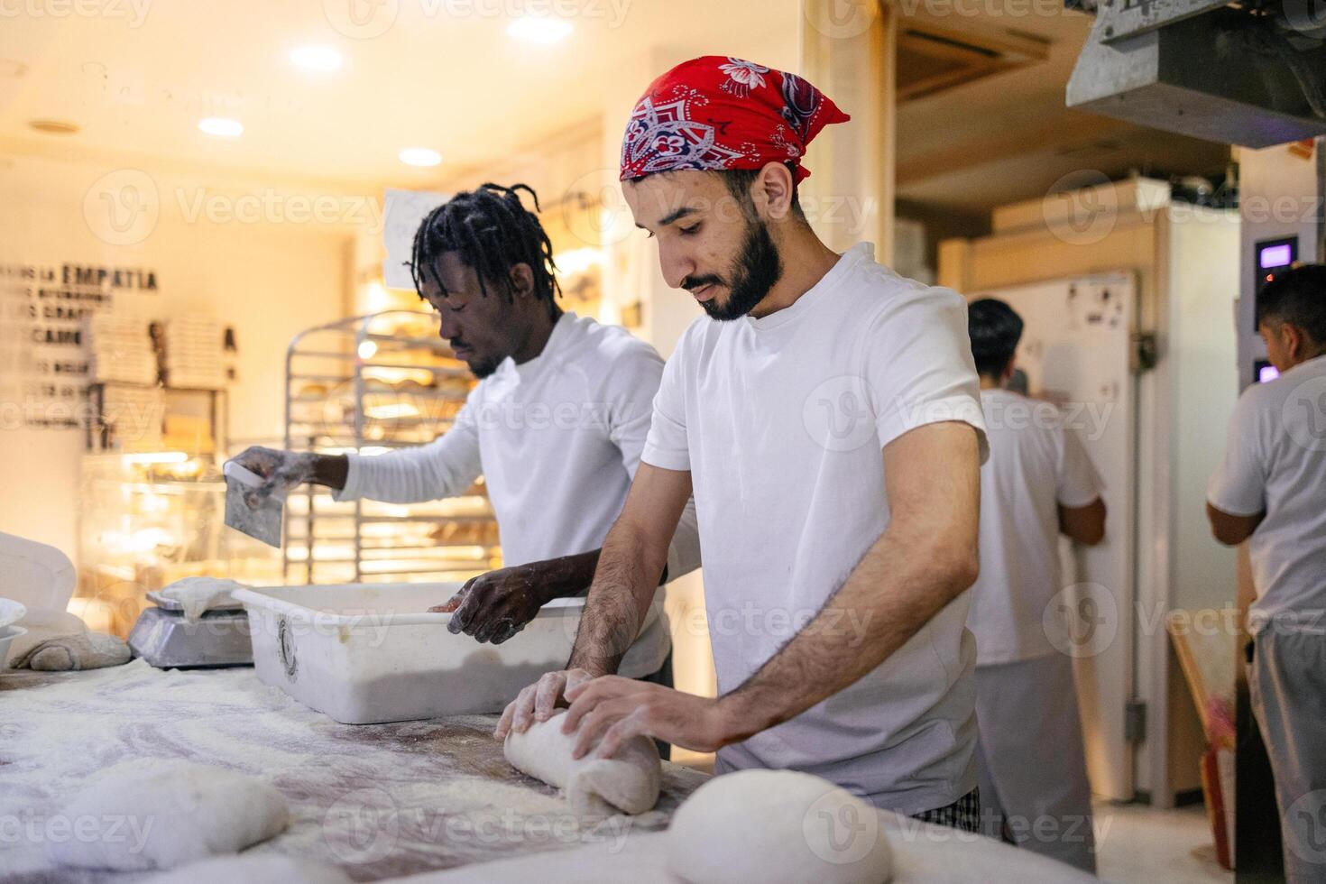 Young arabic baker working on dough photo