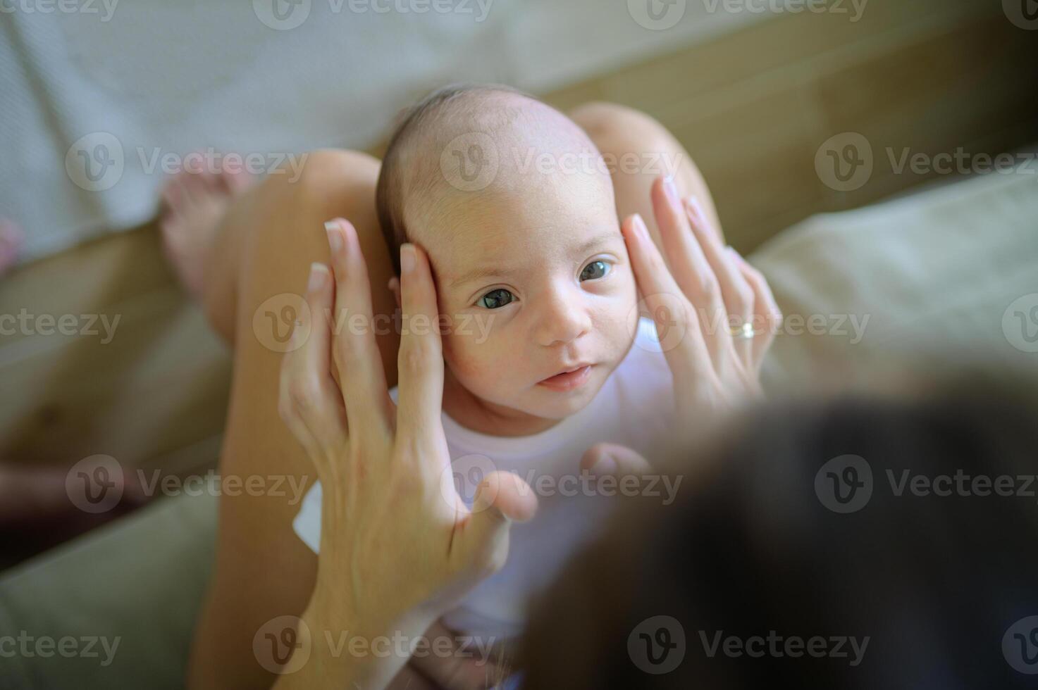 Mother caressing infant on sofa photo
