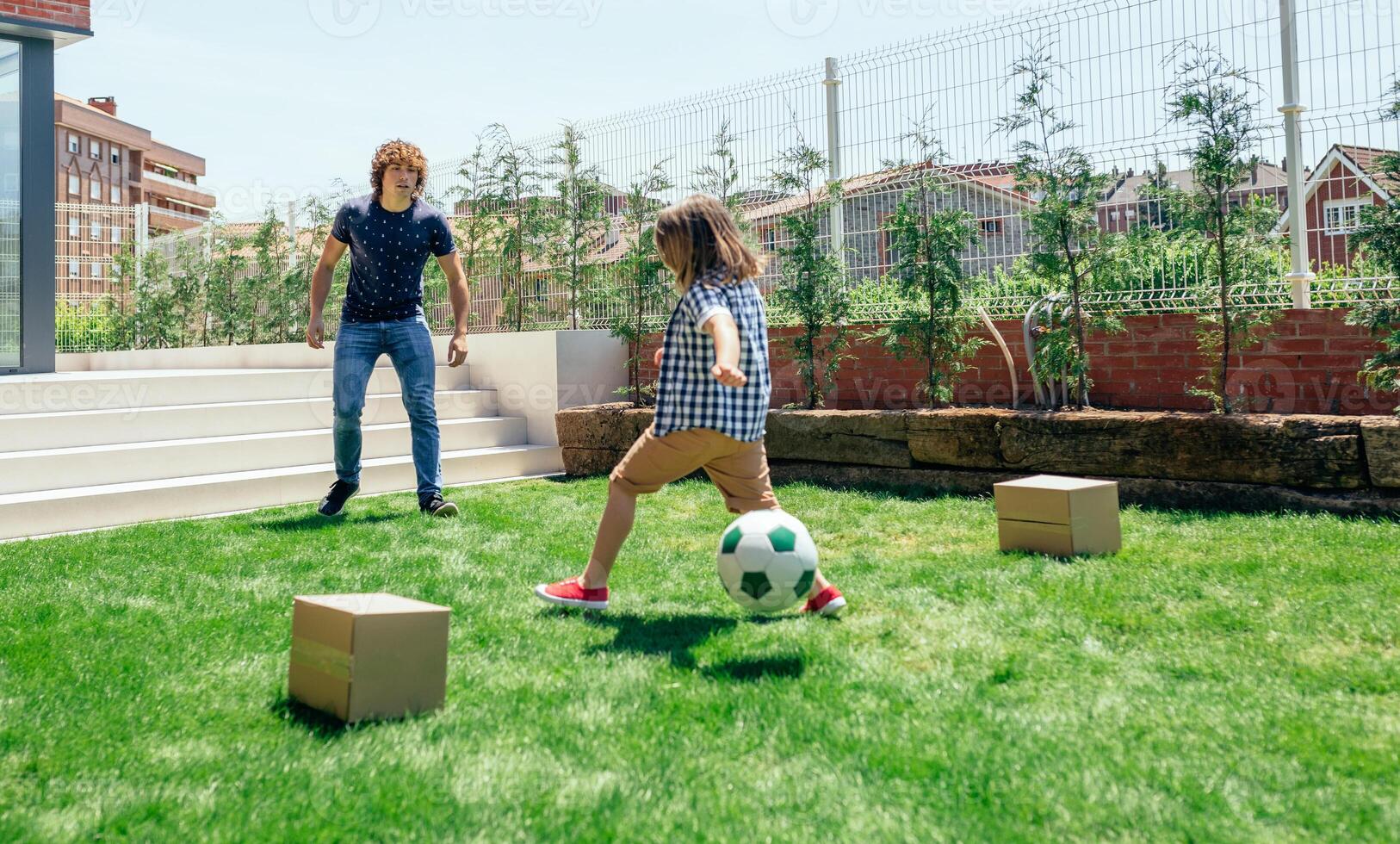 Father and son playing soccer photo